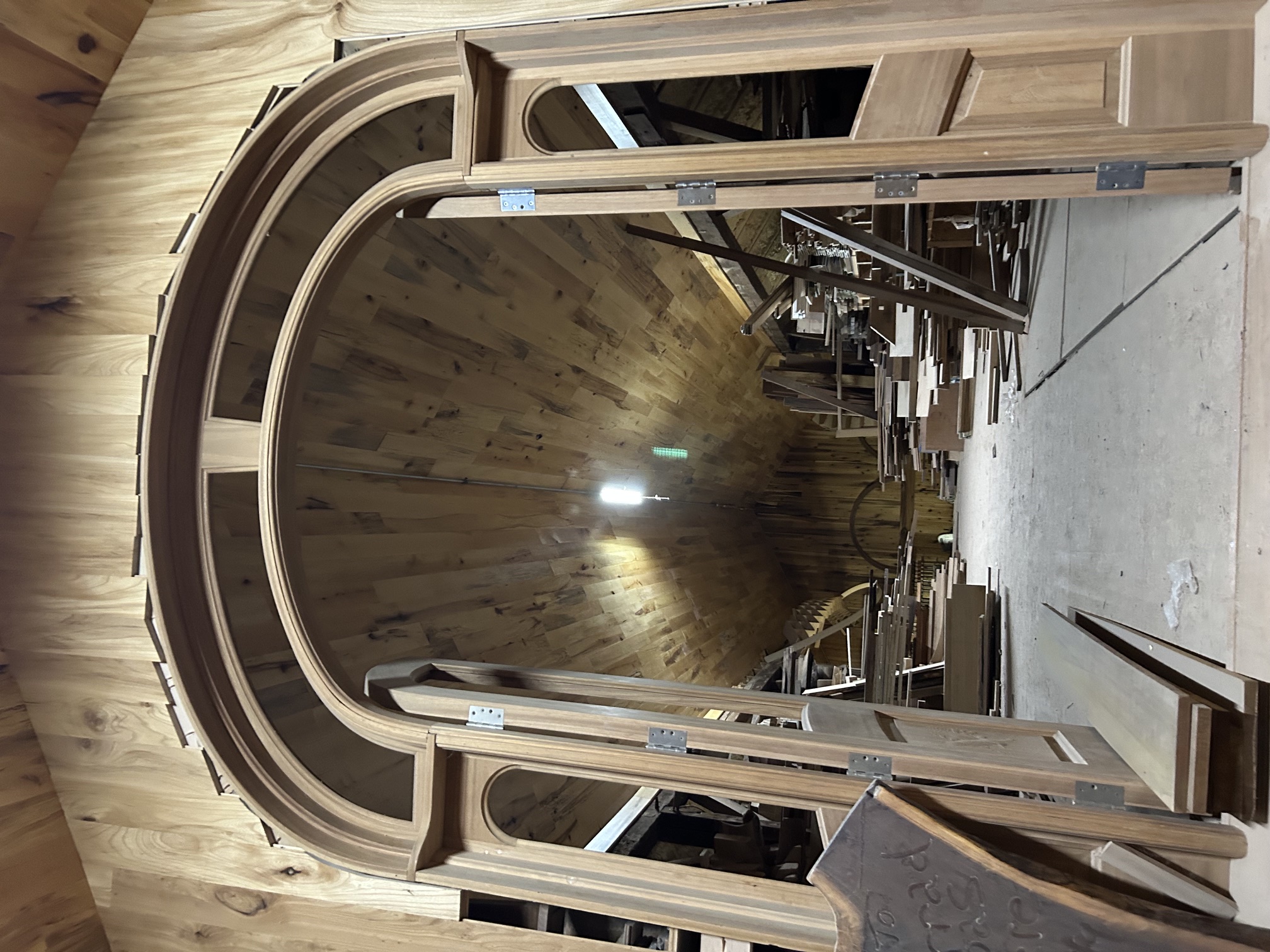 Large custom arched wooden doorway inside Decker Woodworking